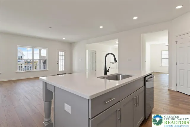 a kitchen with a sink a stove and wooden floor