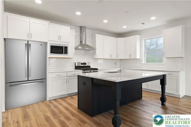 a kitchen with kitchen island a sink stainless steel appliances and window