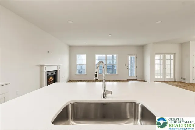 a view of a kitchen island with a sink and dishwasher with wooden floor