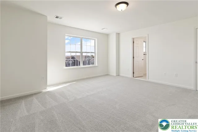 an empty room with windows and closet