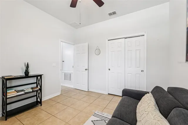 a bedroom with furniture and a chandelier fan
