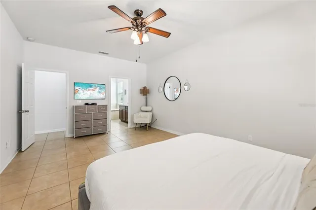 a spacious bedroom with a bed and a chandelier