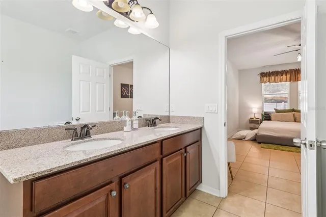 a en suite bathroom with a granite countertop sink and a mirror