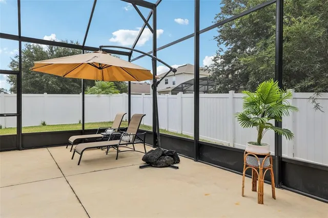 a view of a patio with a table chairs and a backyard