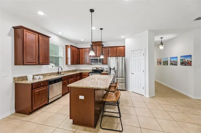 a kitchen with stainless steel appliances granite countertop a stove a sink a refrigerator and cabinets