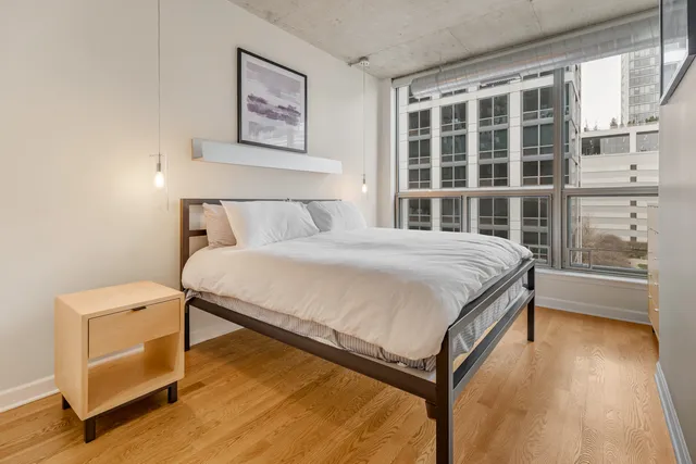 a bedroom with a bed and a large window