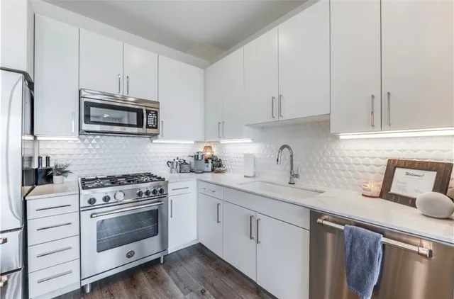 a kitchen with granite countertop white cabinets and white appliances