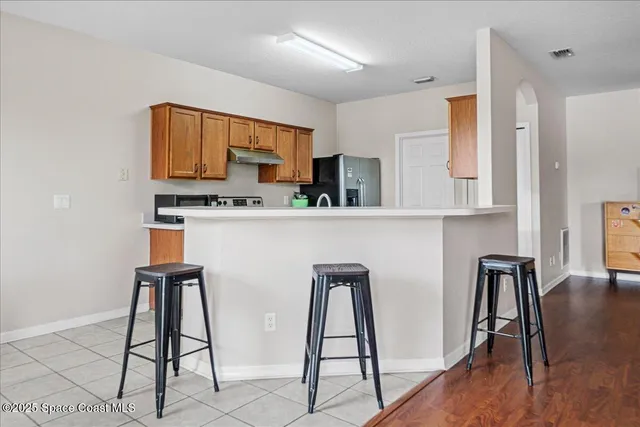 a kitchen with stainless steel appliances kitchen island a refrigerator sink and cabinets