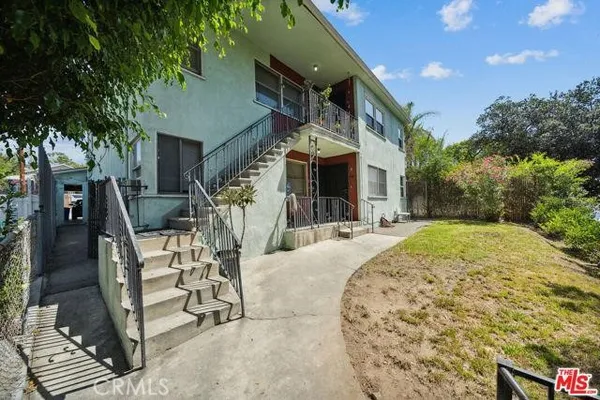a view of a house with backyard and sitting area