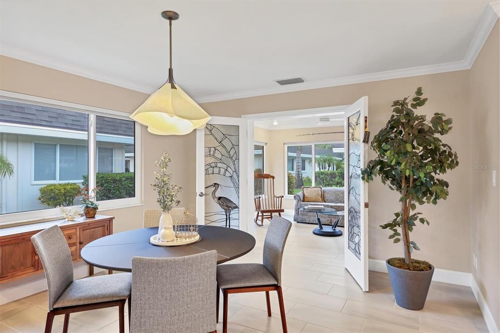 1900 Benjamin Franklin Drive, Unit V15 Sarasota, FL 34236 - Photo 14 of 39 a view of a dining room with furniture window and wooden floor