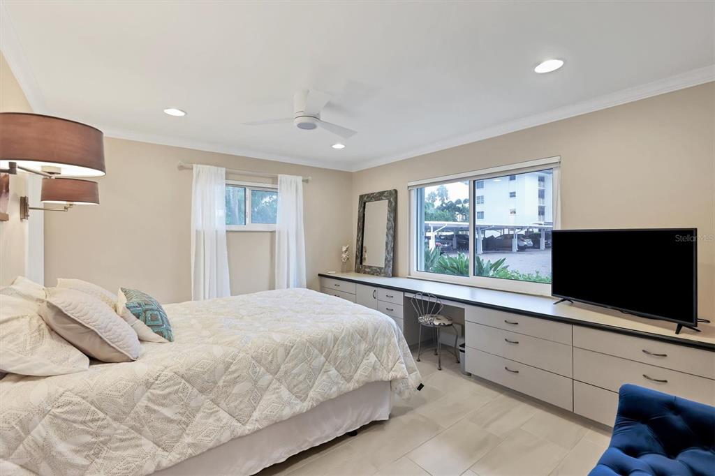 1900 Benjamin Franklin Drive, Unit V15 Sarasota, FL 34236 - Photo 17 of 39 a bedroom with a large bed and a flat tv screen on dresser