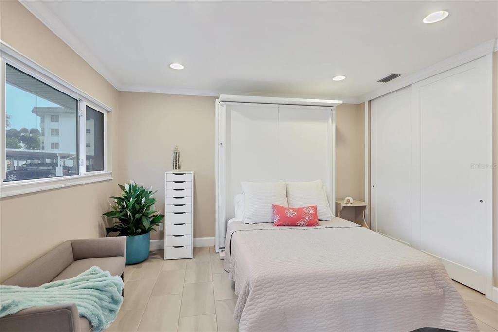 1900 Benjamin Franklin Drive, Unit V15 Sarasota, FL 34236 - Photo 21 of 39 a bedroom with a bed and a potted plant