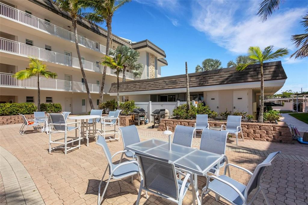 1900 Benjamin Franklin Drive, Unit V15 Sarasota, FL 34236 - Photo 32 of 39 a view of a patio with a table and chairs and potted plants