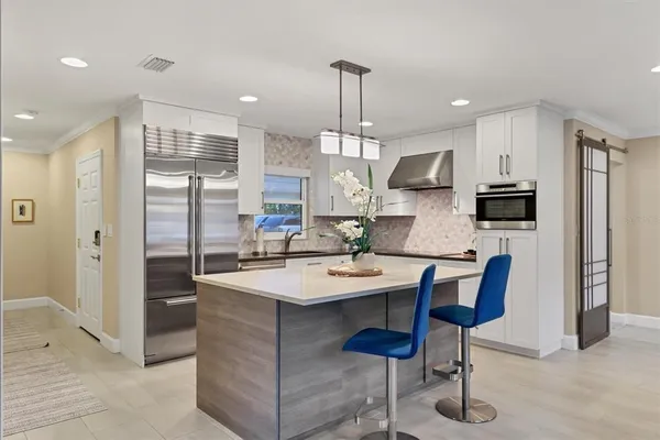a kitchen with stainless steel appliances kitchen island granite countertop a sink a stove and cabinets