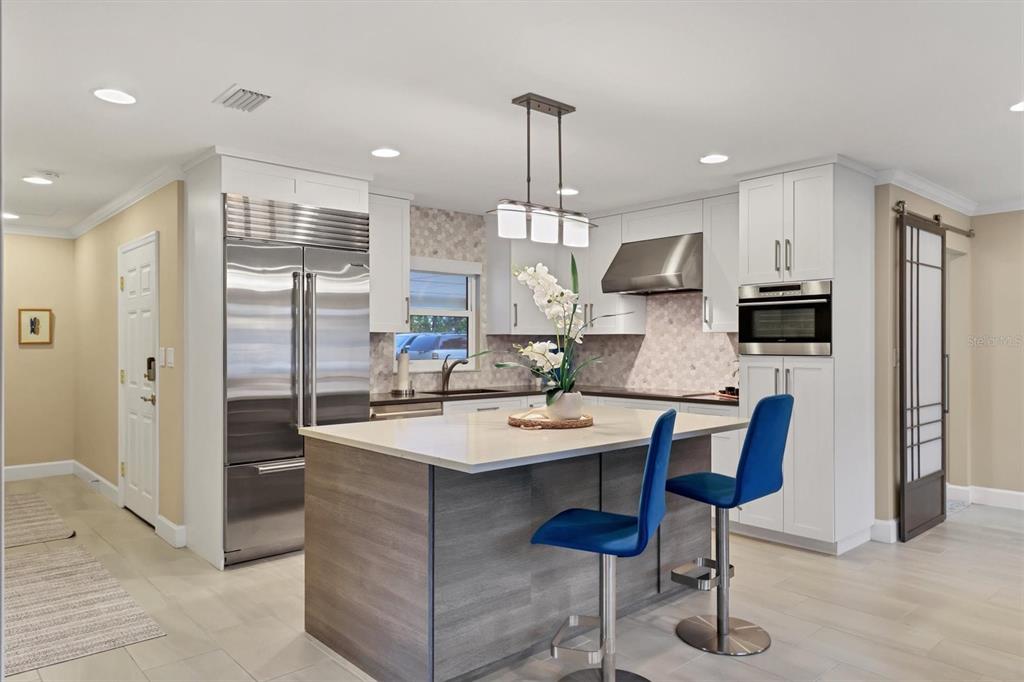 1900 Benjamin Franklin Drive, Unit V15 Sarasota, FL 34236 - Photo 4 of 39 a kitchen with stainless steel appliances granite countertop a sink a stove a refrigerator and island
