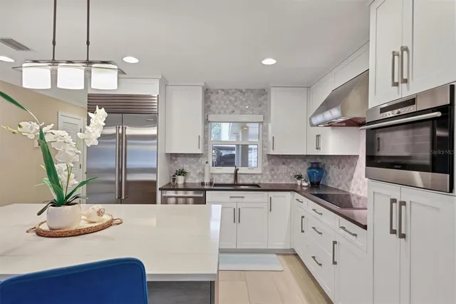 a kitchen with granite countertop a sink stainless steel appliances and cabinets