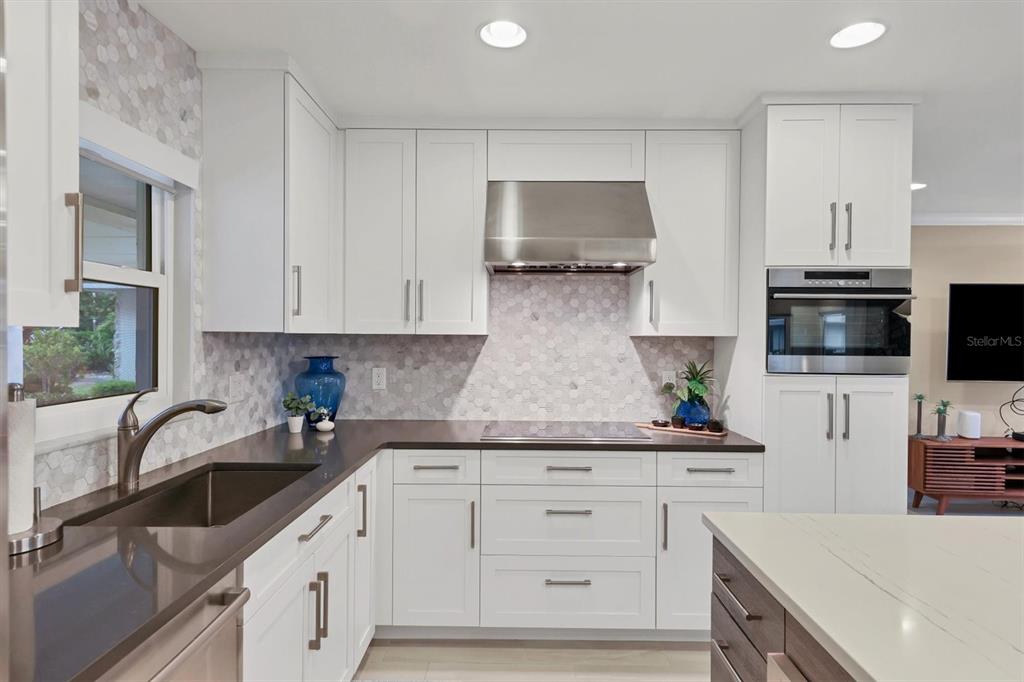 1900 Benjamin Franklin Drive, Unit V15 Sarasota, FL 34236 - Photo 7 of 39 a kitchen with white cabinets and sink