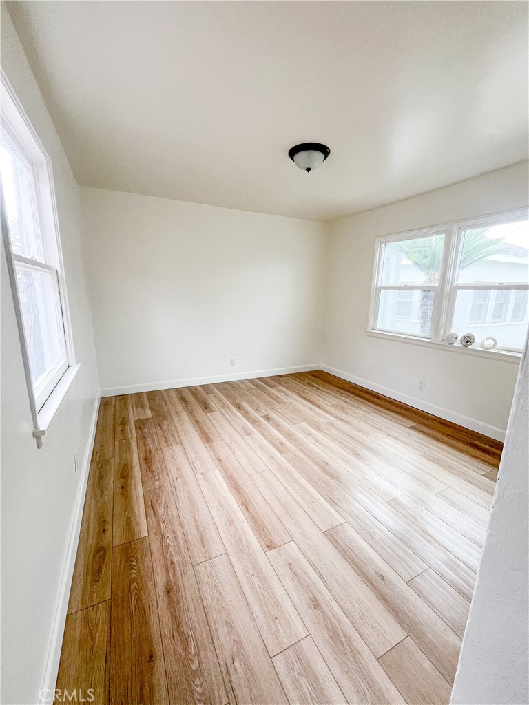 4512 Linsley Street Compton, CA 90221 - Photo 7 of 8 an empty room with wooden floor and windows