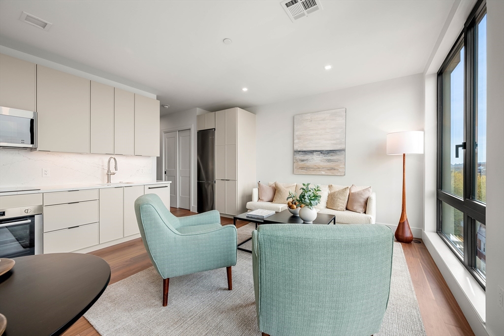 1515 Commonwealth Avenue, Unit 504 Boston, MA 02135 - Photo 12 of 41 a living room with furniture and a large window