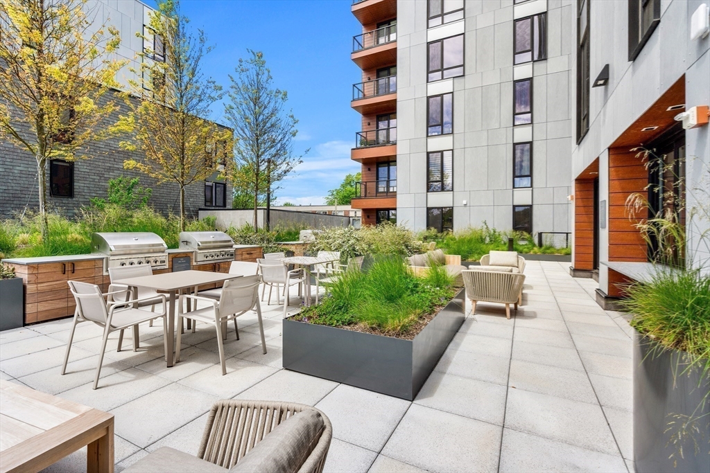 1515 Commonwealth Avenue, Unit 504 Boston, MA 02135 - Photo 33 of 41 a view of a patio with a table and chairs and potted plants