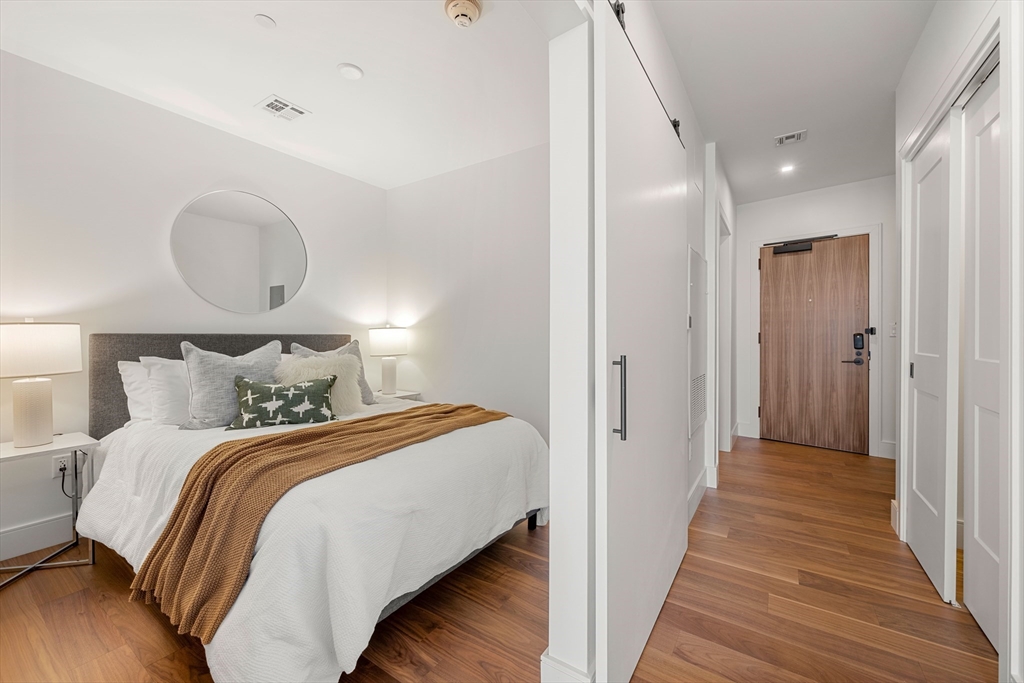 1515 Commonwealth Avenue, Unit 504 Boston, MA 02135 - Photo 6 of 41 a bedroom with bed and wooden floor