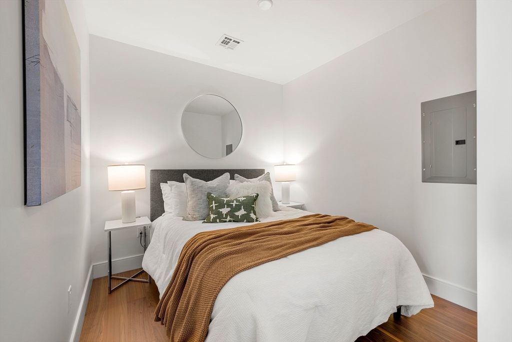 1515 Commonwealth Avenue, Unit 504 Boston, MA 02135 - Photo 7 of 41 a bedroom with bed and wooden floor