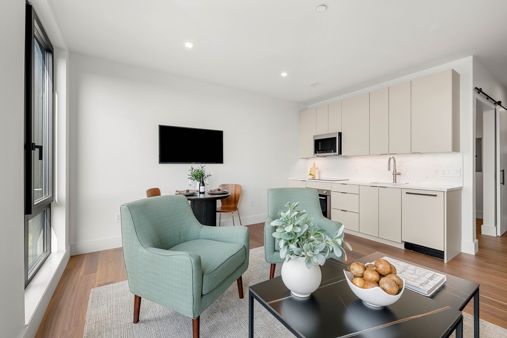 1515 Commonwealth Avenue, Unit 504 Boston, MA 02135 - Photo 9 of 41 a living room with furniture and a flat screen tv