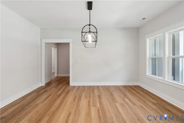 a view of a room with wooden floor and windows
