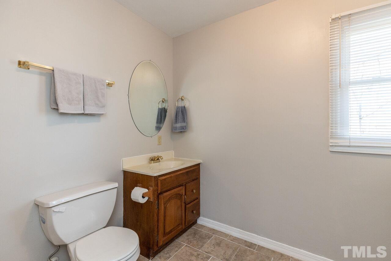 4017 Grimstead Lane Raleigh, NC 27613 - Photo 21 of 30 a bathroom with a toilet a sink and mirror