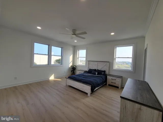 a spacious bedroom with a bed window and a dresser