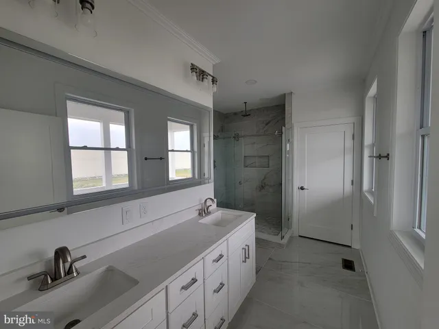 a spacious bathroom with a double vanity sink a mirror and a bathtub