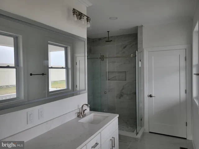 a bathroom with a shower sink and mirror