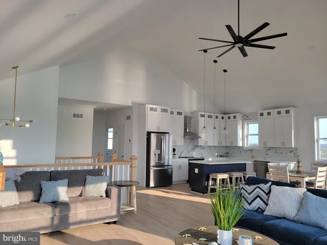 a living room with stainless steel appliances kitchen island granite countertop furniture and a view of kitchen