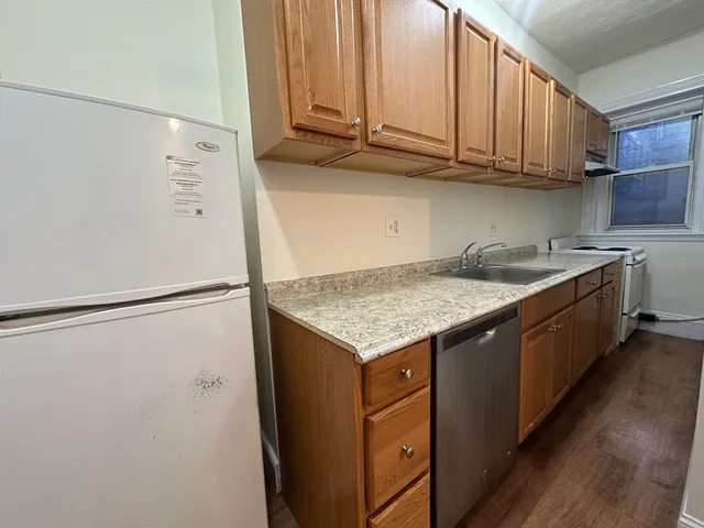 a kitchen with stainless steel appliances granite countertop a refrigerator a sink and a stove