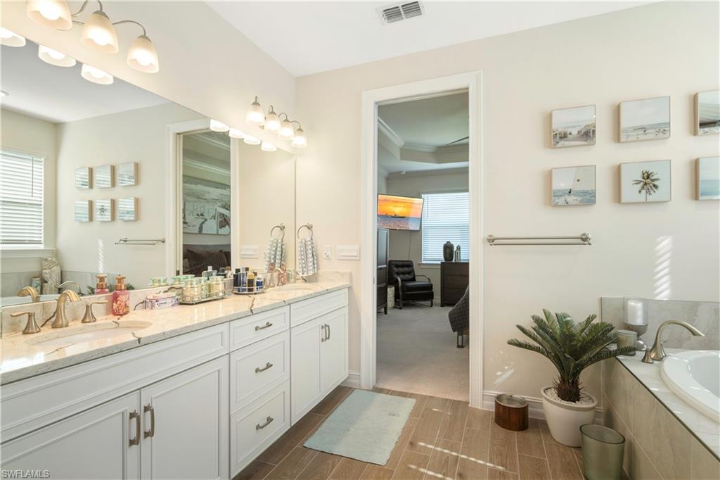 329 Deauville Loop Naples, FL 34114 - Photo 12 of 22 a spacious bathroom with a double vanity sink a mirror and a potted plant