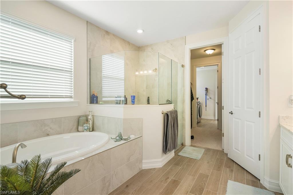 329 Deauville Loop Naples, FL 34114 - Photo 13 of 22 a spacious bathroom with a tub sink and mirror