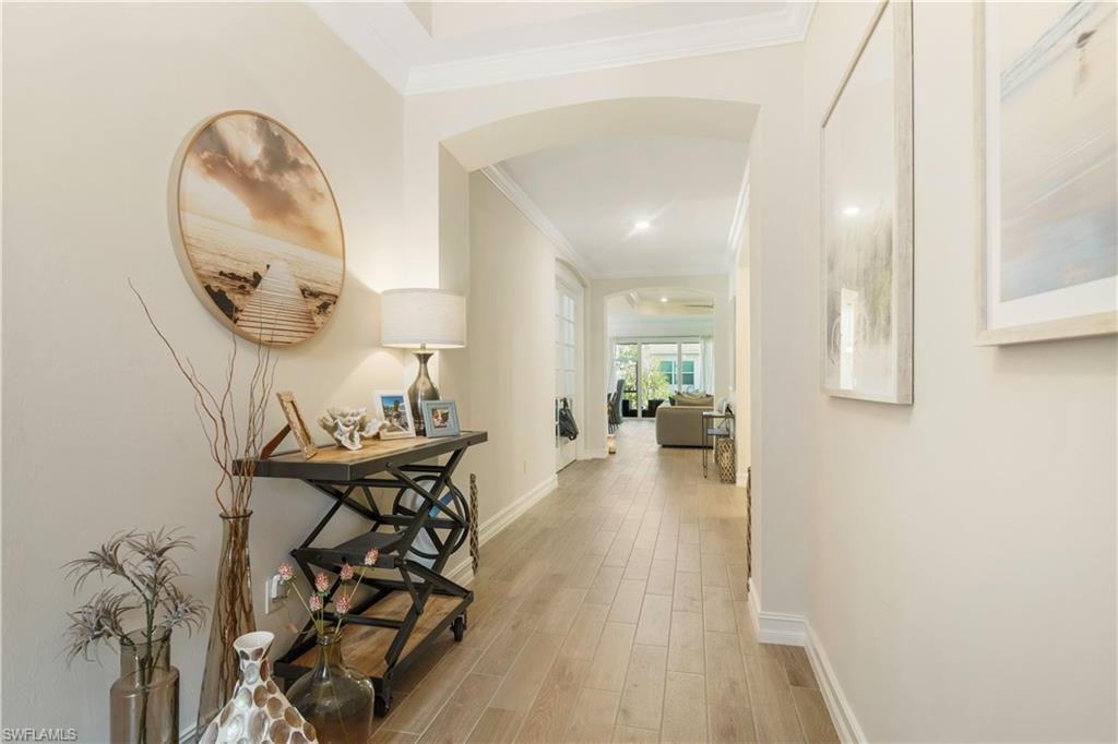 329 Deauville Loop Naples, FL 34114 - Photo 2 of 22 wooden floor with a table and a chair