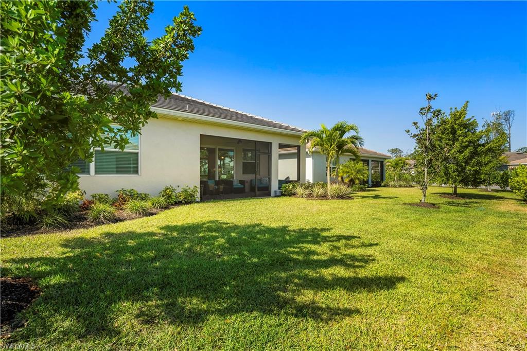 329 Deauville Loop Naples, FL 34114 - Photo 20 of 22 a front view of a house with a yard