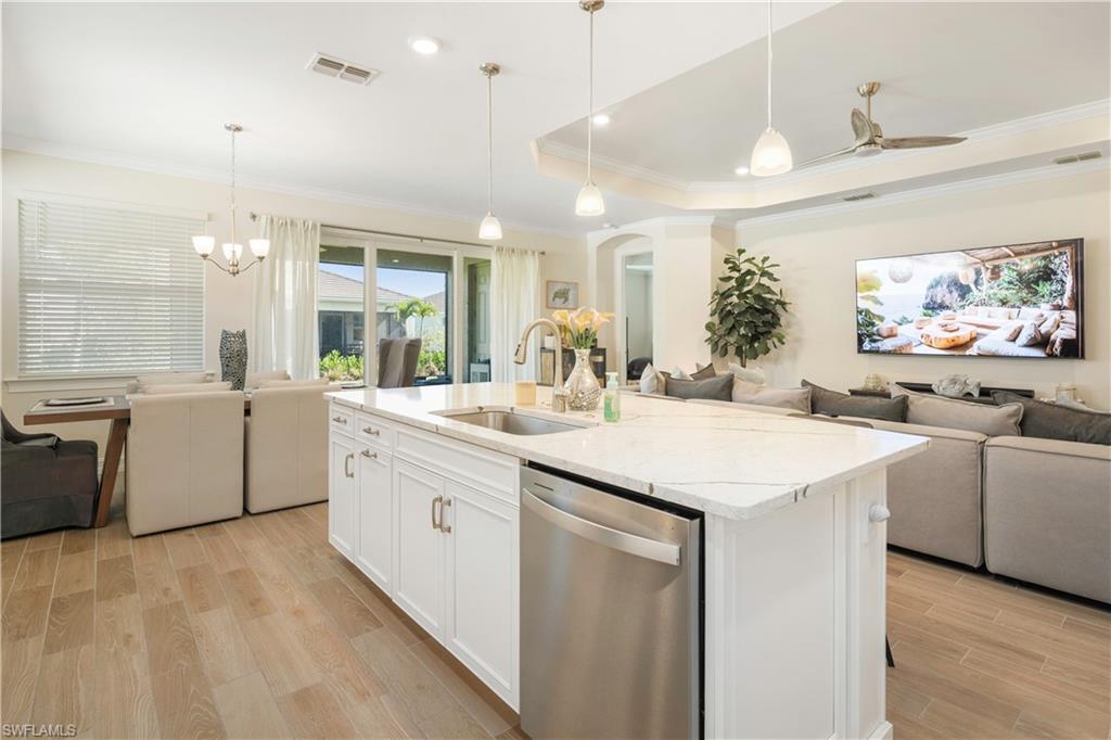 329 Deauville Loop Naples, FL 34114 - Photo 22 of 22 a kitchen with counter top space sink and stainless steel appliances
