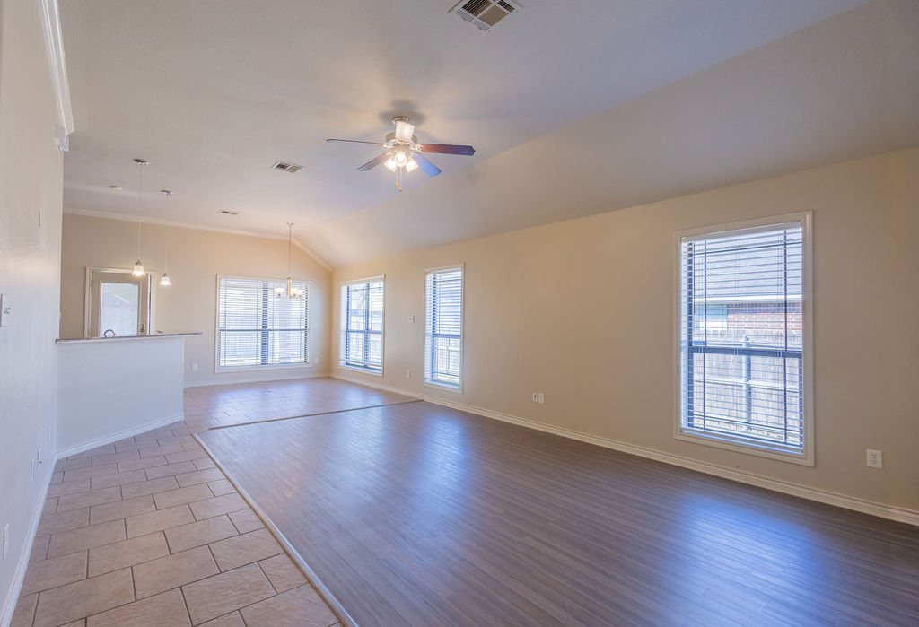 3309 Keefer Loop College Station, TX 77845 - Photo 5 of 27 an empty room with wooden floor chandelier fan and windows