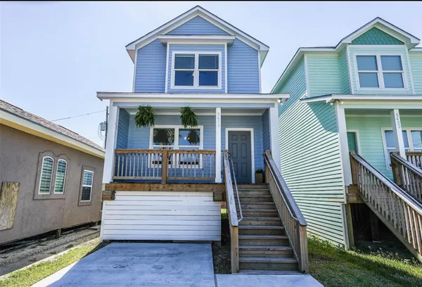 a view of a house with wooden stairs and a small yard