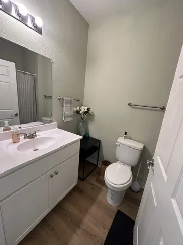 a bathroom with a granite countertop toilet sink and mirror