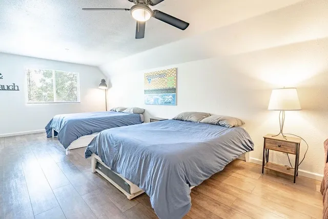 a bedroom with two beds and painting on the wall