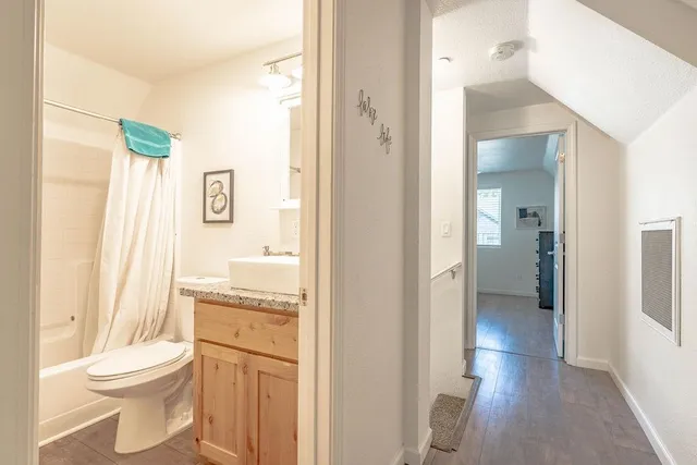 a bathroom with a granite countertop toilet a sink and a mirror