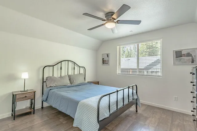 a bedroom with a bed a chandelier and a window