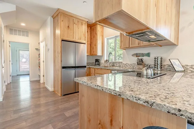 a kitchen with stainless steel appliances granite countertop a refrigerator and a sink