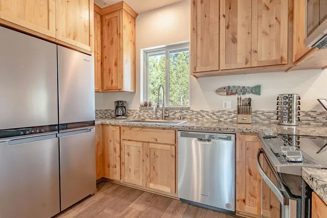 a kitchen with stainless steel appliances granite countertop a refrigerator sink and cabinets