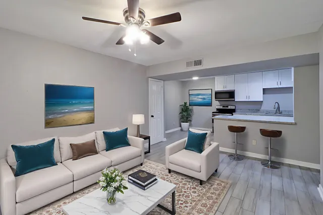 a living room with furniture and kitchen view