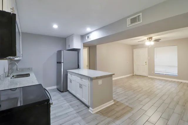 a kitchen with a sink cabinets and wooden floor