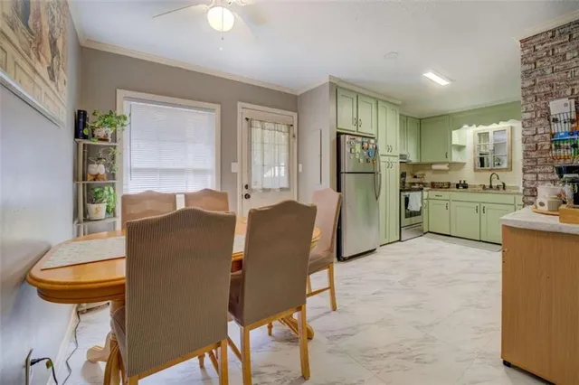 a living room with stainless steel appliances furniture a rug and a kitchen view
